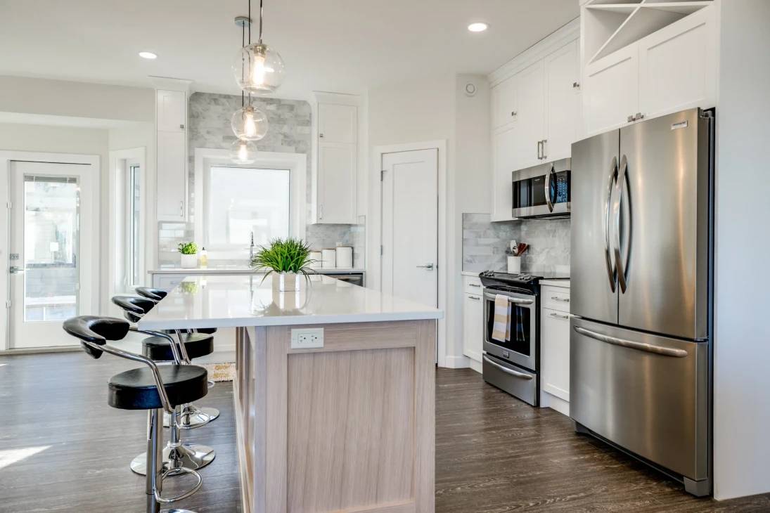 Modern kitchen featuring stainless steel appliances and a spacious center island for cooking and dining.