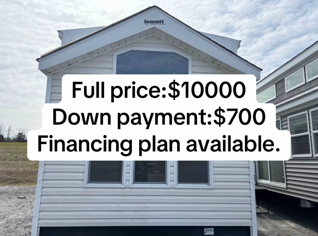 Exterior view of a small white house with large windows. Text overlay states: "Full price: $10,000, Down payment: $700, Financing plan available."