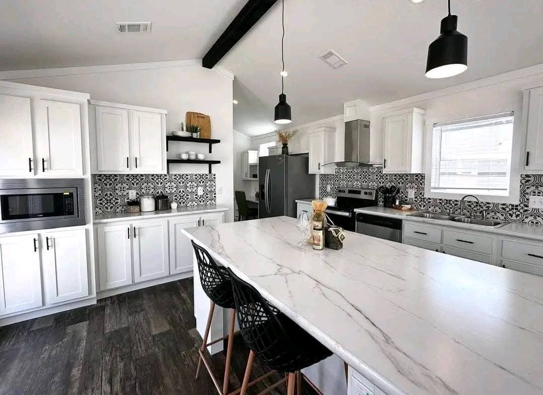 A modern kitchen featuring white cabinets and sleek black countertops.