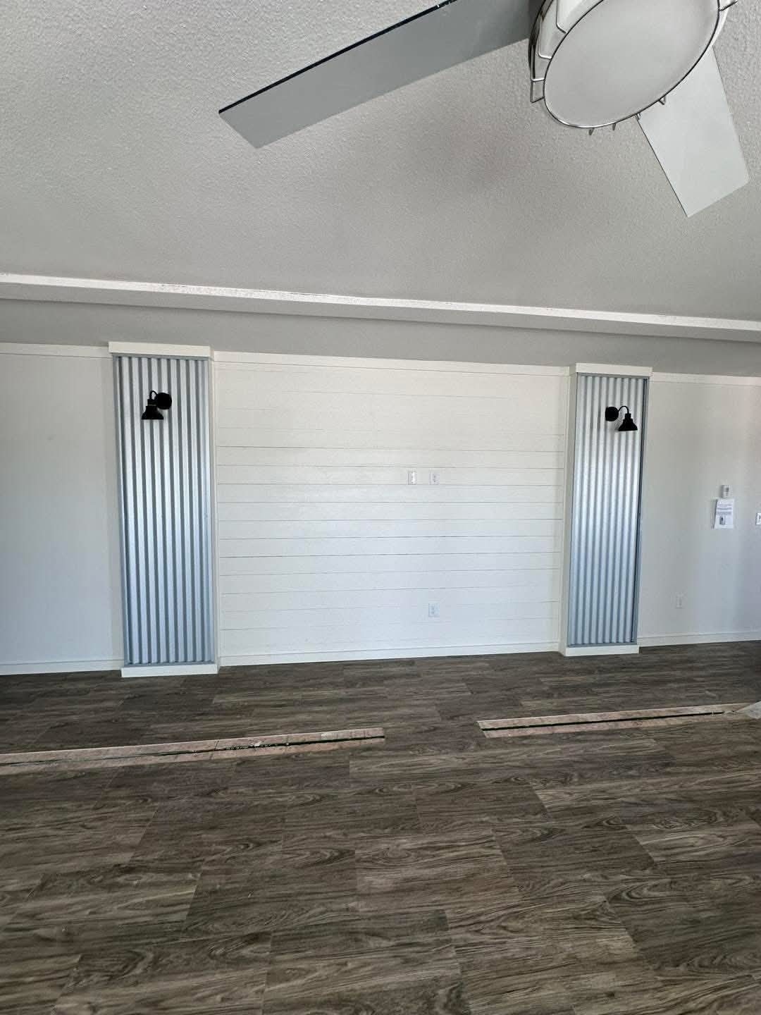  Interior view of a room with a ceiling fan overhead and rich wood flooring, enhancing the cozy ambiance.
