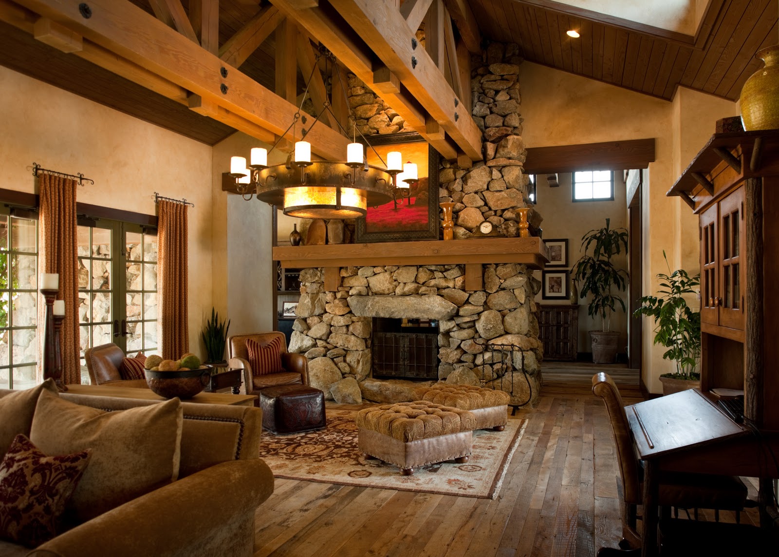Rustic living room with exposed wooden beams and a stone fireplace. Warm lighting, cozy sofas, and earthy tones create an inviting, serene atmosphere.