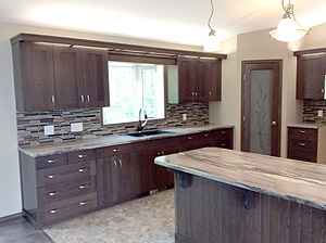 Modern kitchen with dark wood cabinets, stone backsplash, and central island. Bright lighting from pendant lamps, creating a warm, inviting ambiance.