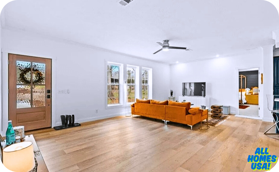 Living room with orange couch and large windows. Image for illustrative purpose.