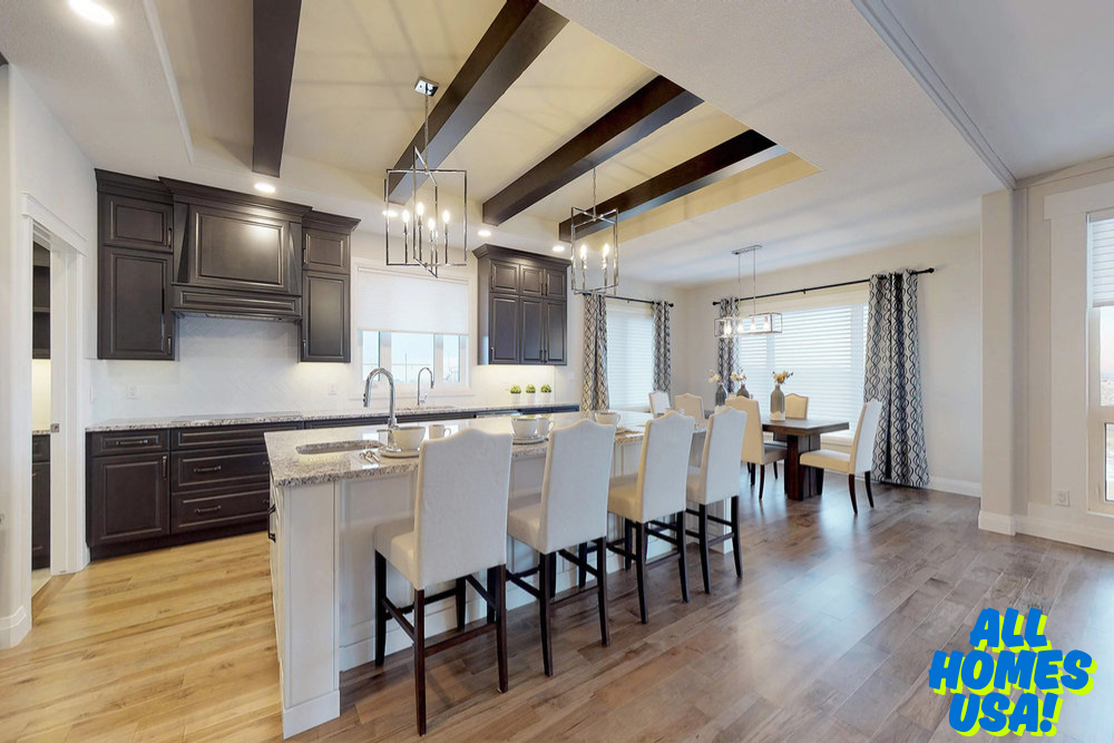 Spacious kitchen and dining area with dark wood cabinetry, marble countertop, white chairs, and modern pendant lights. Bright and welcoming ambiance. Image for illustrative purpose.