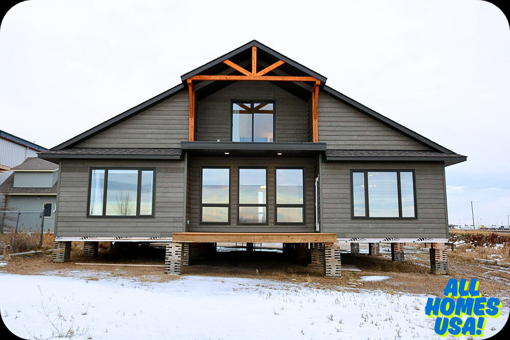 A wooden-framed house surrounded by snow, under a clear sky, showcasing its cottage-style architecture and multiple windows. Image for illustrative purpose.