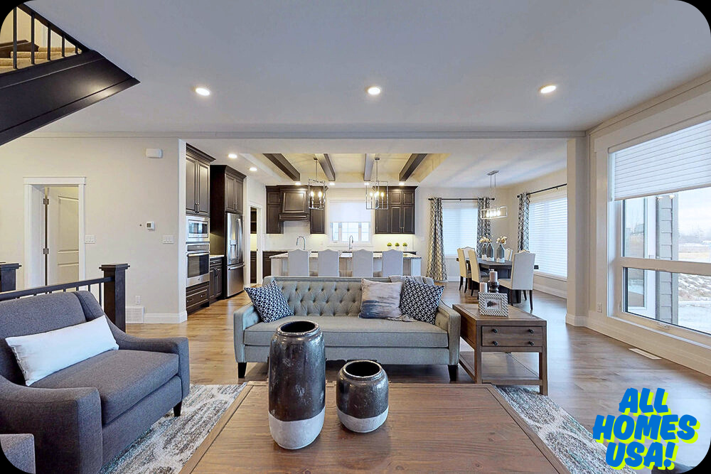 Stylish, open-concept living room and kitchen with modern decor. Features a gray sofa, armchair, wood accents, and dining area. Bright, airy ambiance. Image for illustrative purpose.
