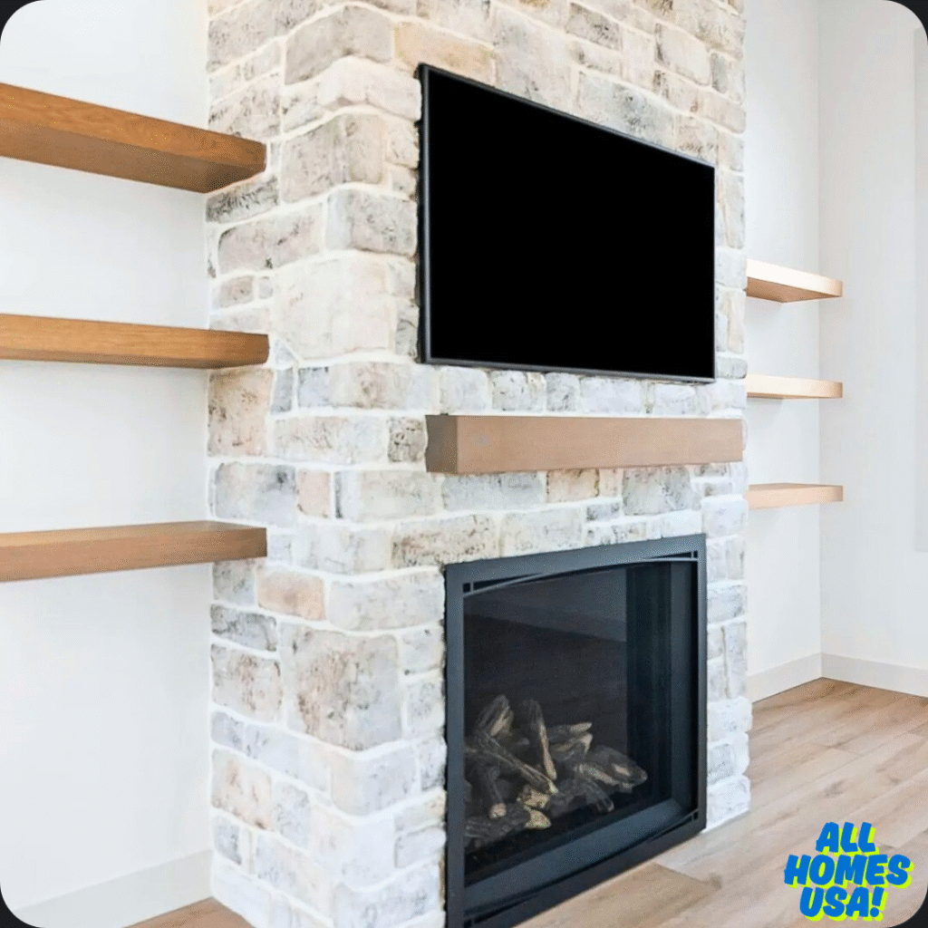 Modern living room with a stone fireplace featuring a mounted TV above. Wooden shelves flank both sides, creating a cozy, minimalist aesthetic. Image for illustrative purpose.