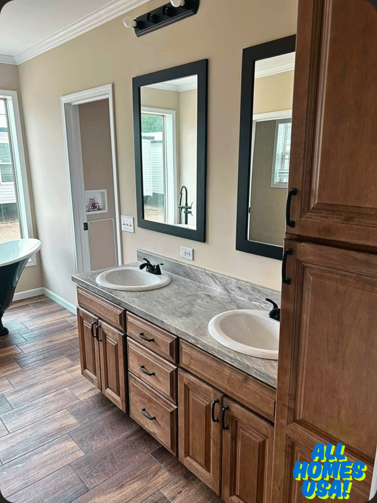 Modern bathroom with dual sinks and mirrors on wooden cabinets. Natural light filters through a window, reflecting on polished wood floors. Cozy and elegant. Image for illustrative purpose.