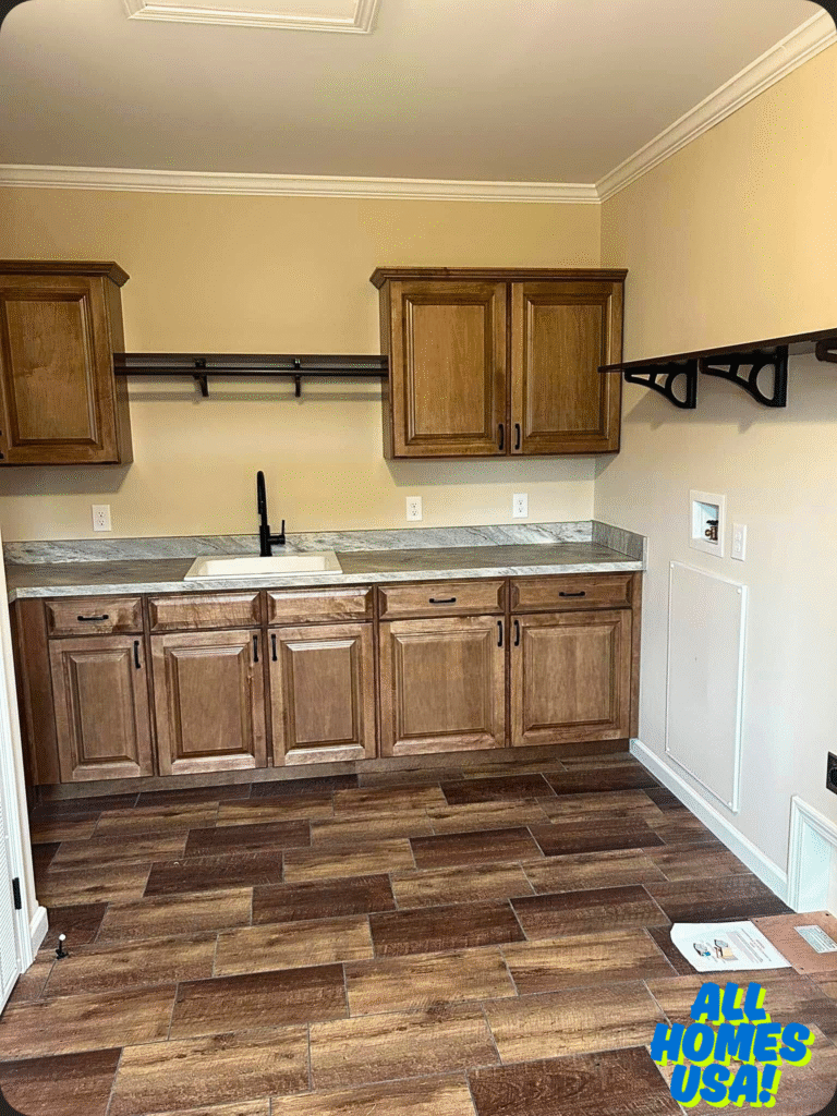 Rustic kitchen interior with light wood cabinets and a stone countertop. The room features a white sink, black faucet, and warm wooden floor tiles. Image for illustrative purpose.