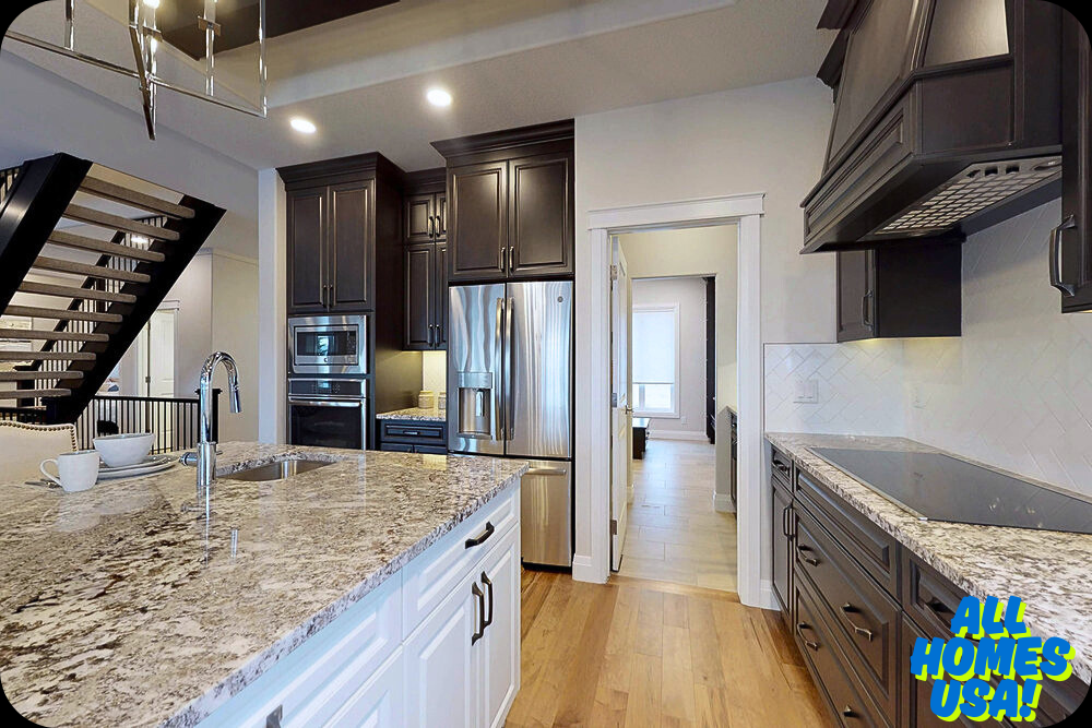 Modern kitchen with dark wood cabinets, stainless steel appliances, and a granite island. Light wood flooring and an open staircase add elegance. Image for illustrative purpose.