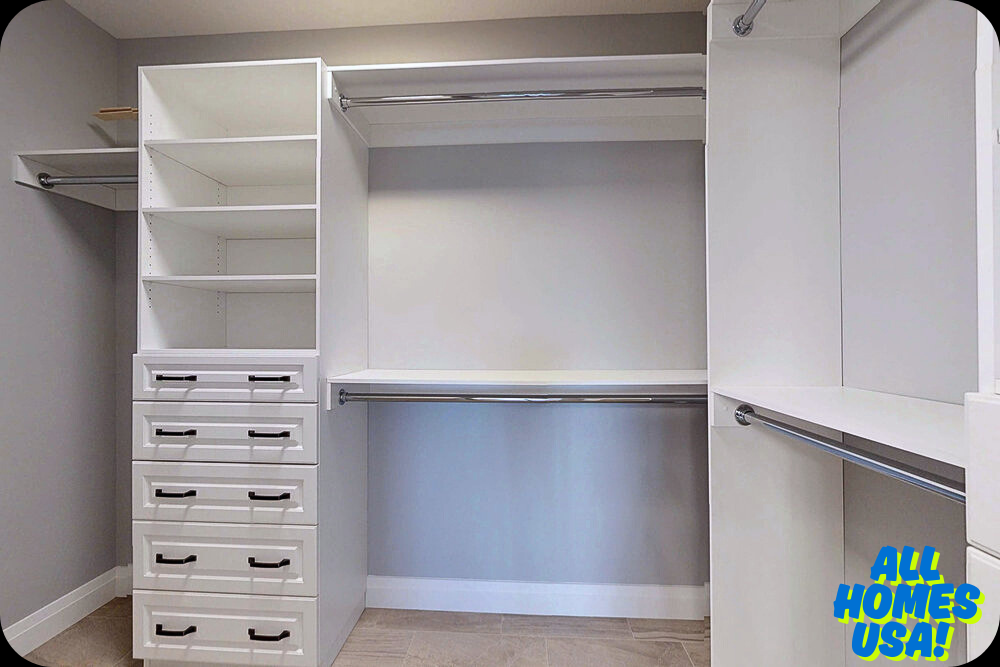 A spacious, modern walk-in closet with white shelves, drawers, and multiple hanging rods. The room has a clean and organized tone. Logo reads "All Homes USA!". Image for illustrative purpose.