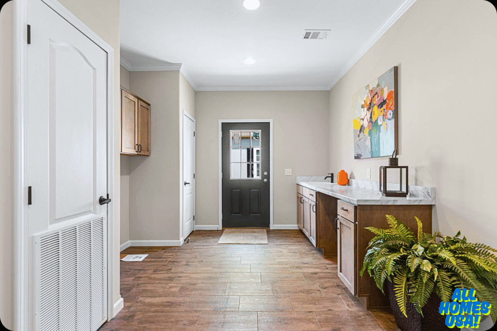 A modern entryway features wooden flooring, a black door, and light walls. The right has a marble-topped cabinet with decor, a vibrant floral painting, and a potted fern, creating a welcoming atmosphere. Image for illustrative purpose.