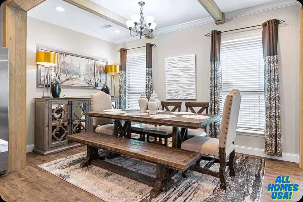 Warm dining room with a rustic wooden table and bench, beige upholstered chairs, and decorative vases. Two windows with patterned curtains, modern art, and gold lamps enhance the cozy ambiance. Image for illustrative purpose.
