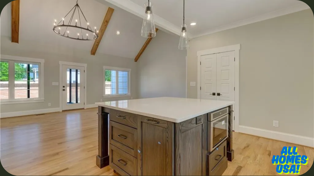 Spacious open-concept kitchen with high vaulted ceilings, wooden beams, and a chandelier. Features a large island, light wood floors, and ample natural light. Image for illustrative purposes.