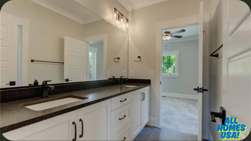 Modern bathroom with a double-sink vanity, black countertops, white cabinets, and sleek faucets. Open door reveals a bright bedroom with a ceiling fan. Image for illustrative purposes.