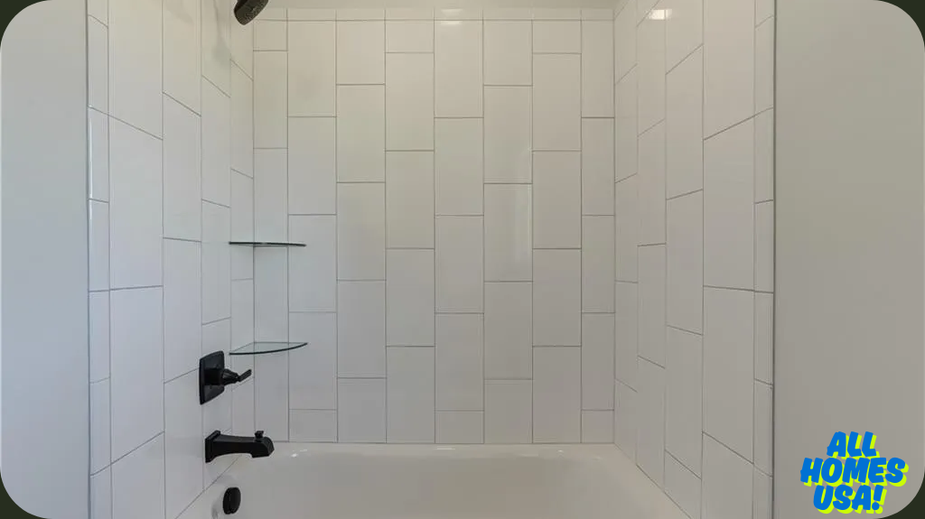 A bathroom features a white tiled shower with a modern grid pattern, black fixtures, and glass corner shelves. The clean design conveys simplicity. Image for illustrative purposes.