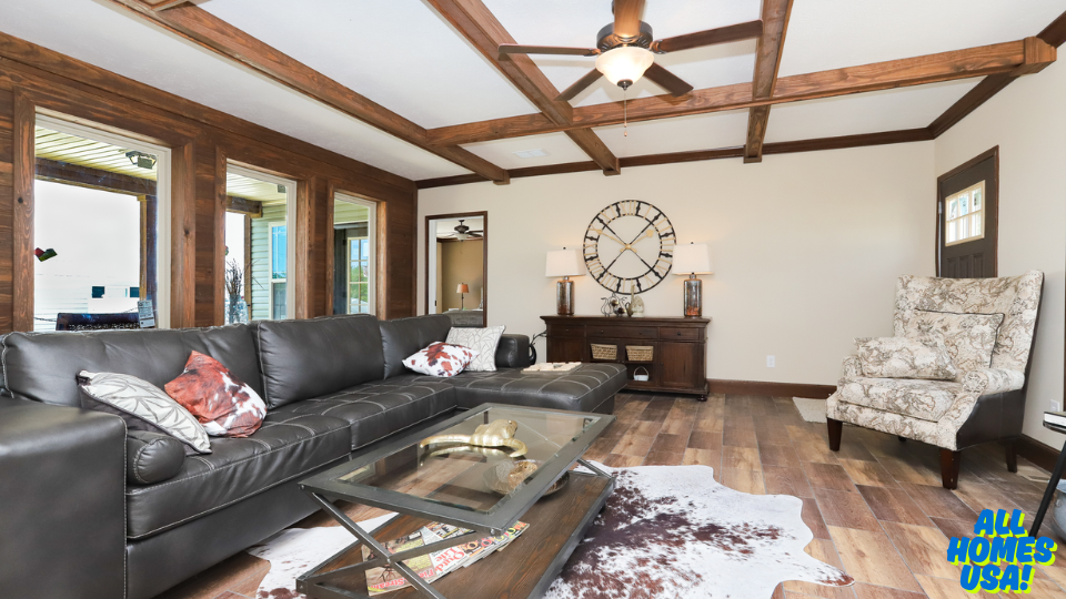 Spacious living room with a black leather sofa, patterned armchair, and cowhide rug. Large windows brighten the space. A wall clock decorates the wall, adding a modern touch. Image for illustrative purposes.