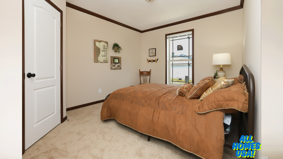 A cozy bedroom with beige walls and brown trim. It features a brown bedspread, decorative pillows, a wooden chair, a lamp, and wall art. The mood is warm and inviting. Image for illustrative purposes.